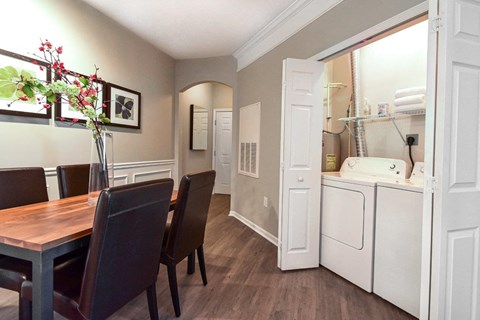 A dining room with a table and chairs.