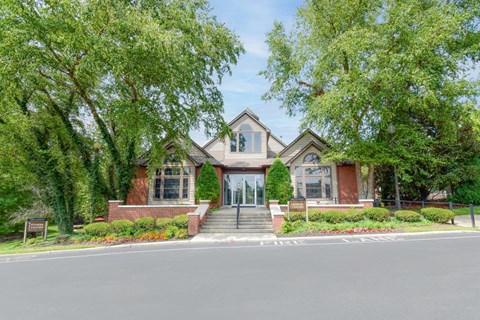 A house with a red brick facade and a large front yard.