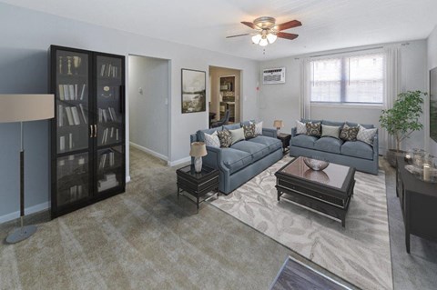 A living room with a grey couch and a black coffee table.