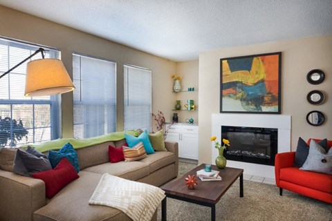 A living room with a fireplace and a painting on the wall.