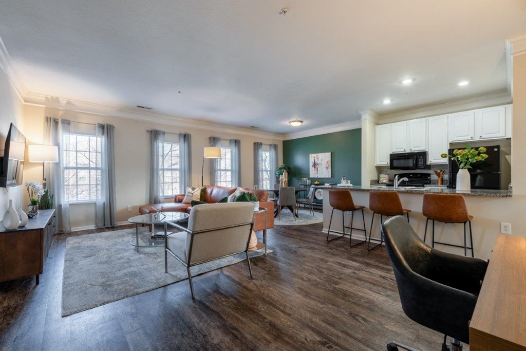 a living room with a couch and chairs and a kitchen