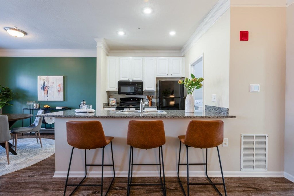 a kitchen with a counter top with three stools