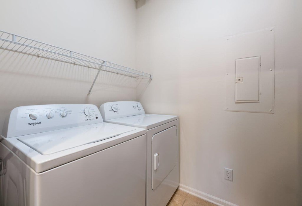 a washer and dryer in a room with a white wall and a door
