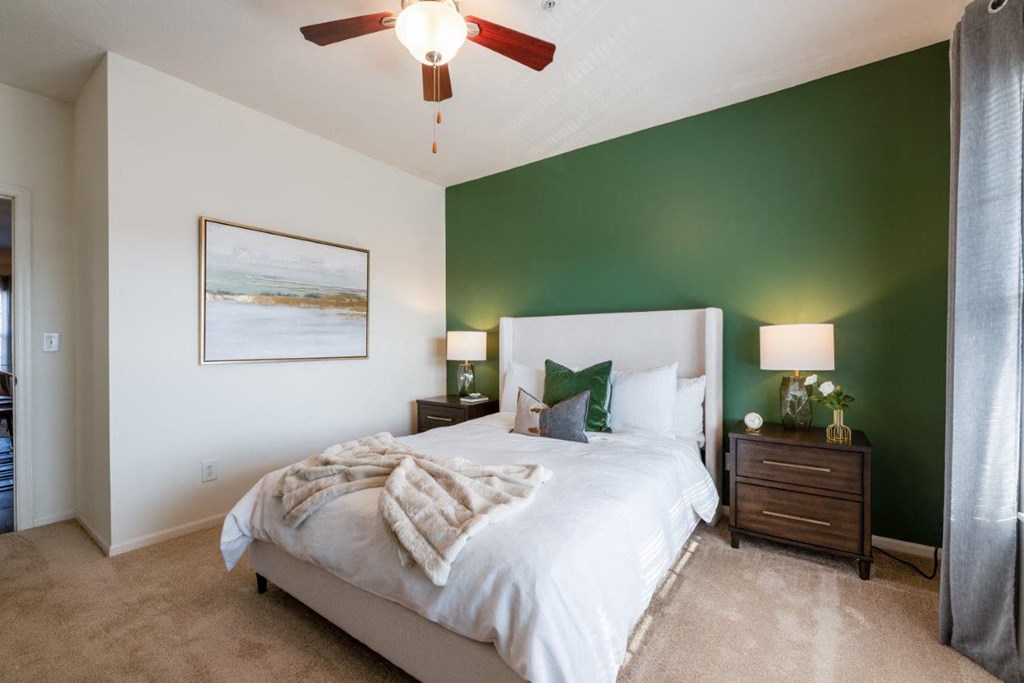 a bedroom with a bed and a ceiling fan