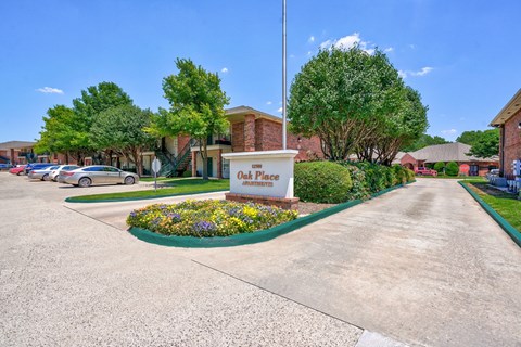 A sign that says Oak Place is in front of some buildings.