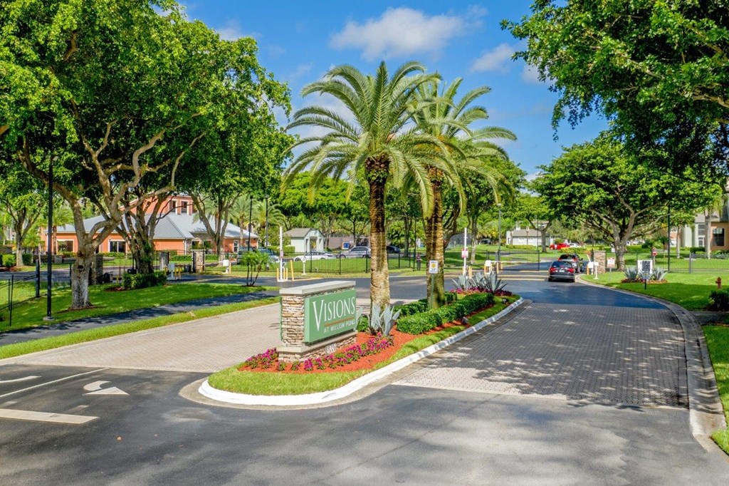 A street view of a residential area with a sign that reads "VISIONS".