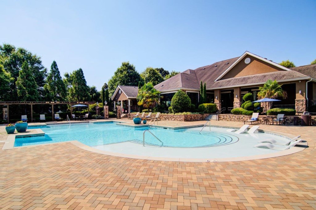 a large swimming pool with a house in the background