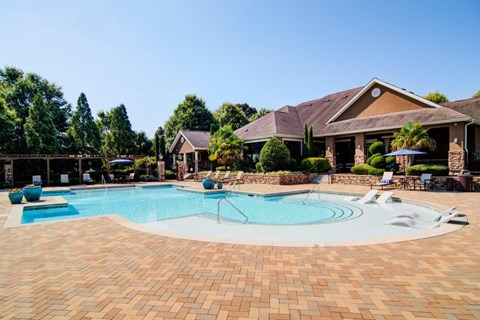 a large swimming pool with a house in the background