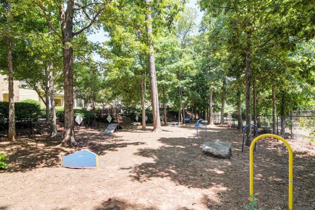a park with trees and a yellow swing set