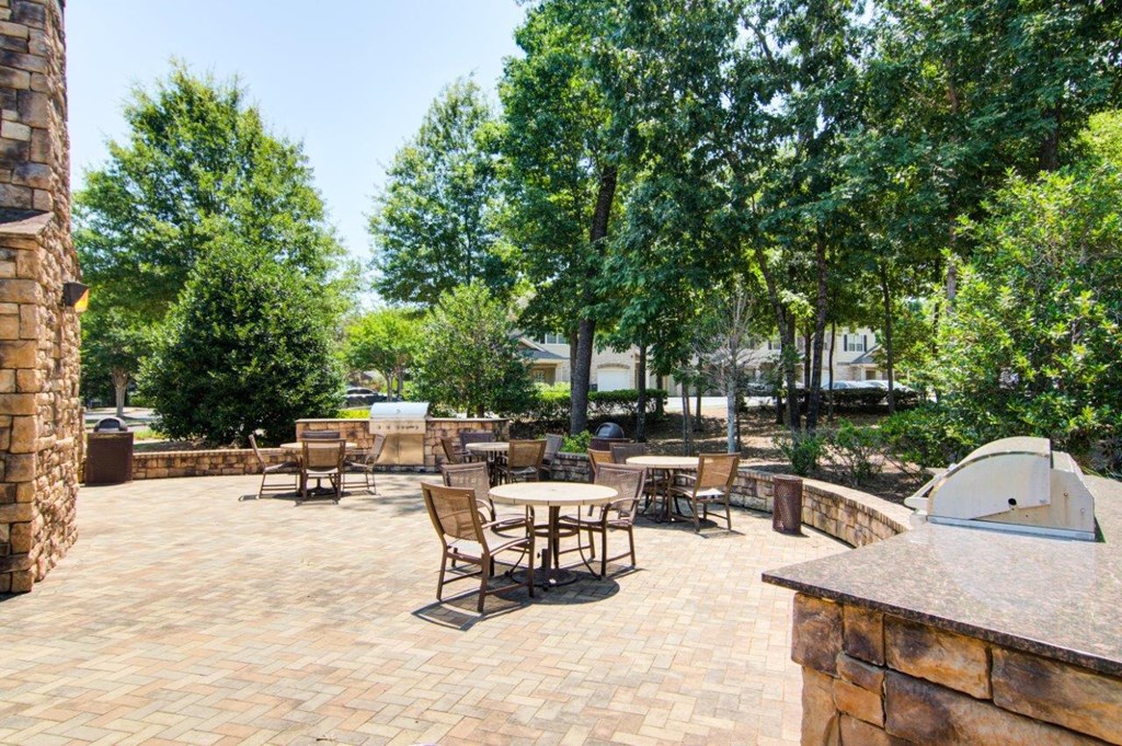 a large patio with tables and chairs and trees