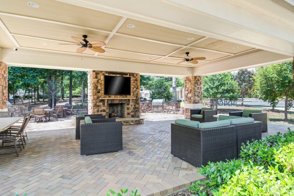 a covered patio with furniture and a fireplace