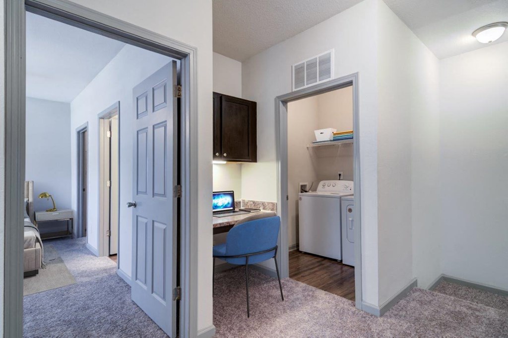 a view of a living room with a desk and a kitchen