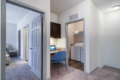 a view of a living room with a desk and a kitchen