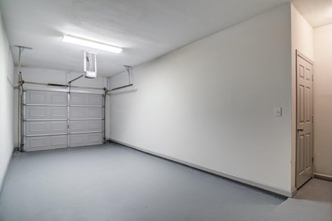 an empty garage with white walls and doors