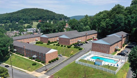 A large building complex with a pool in the foreground.