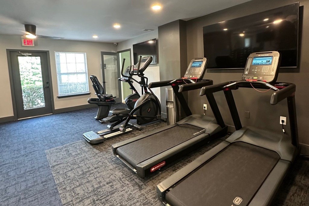 A gym with treadmills and elliptical machines.