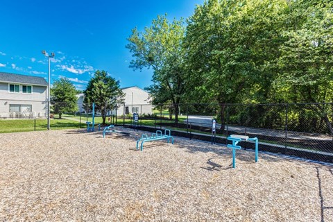 A playground with blue equipment and a fence.