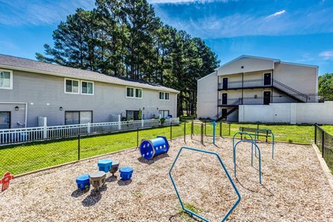 A playground with a blue slide and a red slide.