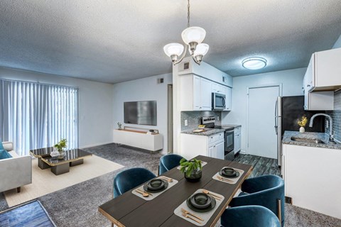 A modern kitchen with a dining table set for two.