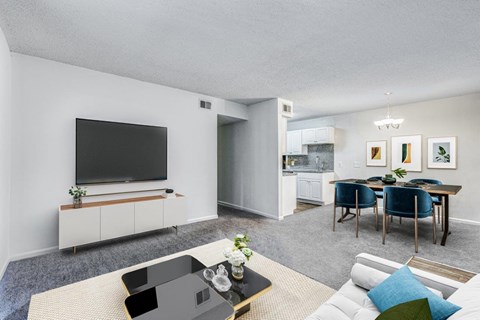 A modern living room with a television, sofas, and a dining table.