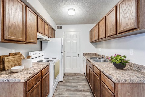 A kitchen with wooden cabinets and a white refrigerator.
