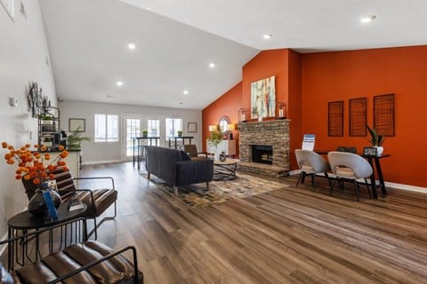 living room with orange accent wall and wooden floors and a fireplace