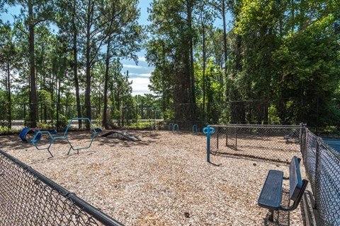A playground with a swing set and a bench.