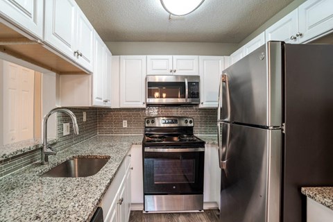 A kitchen with a stove, oven, and refrigerator.