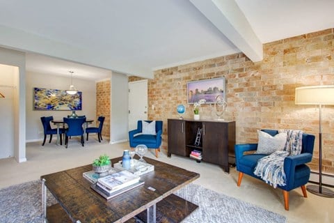 a living room with a brick wall and blue furniture
