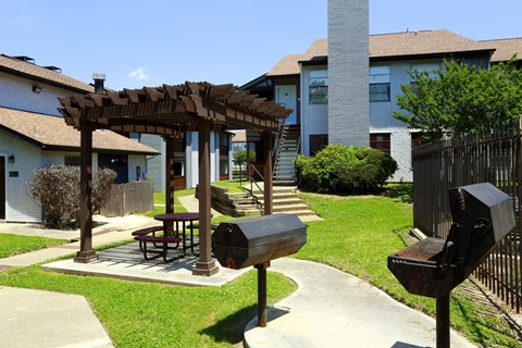 A patio with a picnic table and a grill.