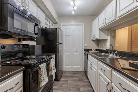 a kitchen with black appliances and white cabinets