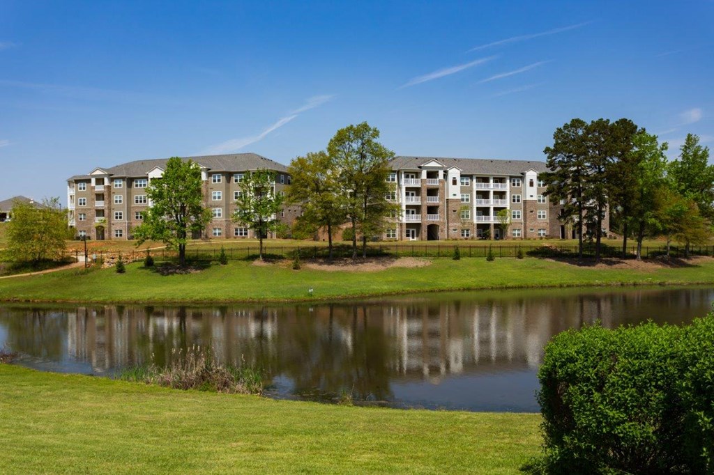 a large pond in front of an apartment building