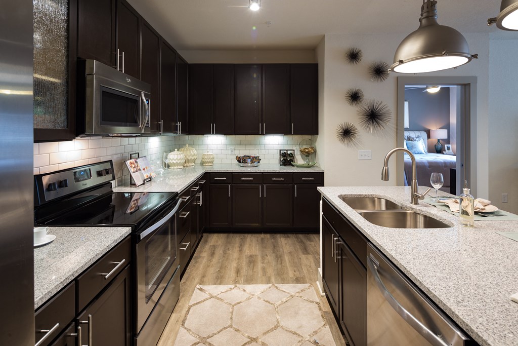 a large kitchen with stainless steel appliances and granite counter tops