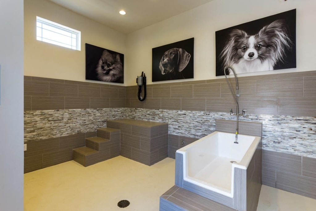 a large bathroom with a tub and a sink and pictures of dogs