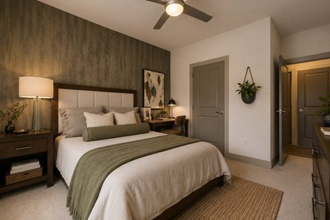A bedroom with a large bed and a ceiling fan.