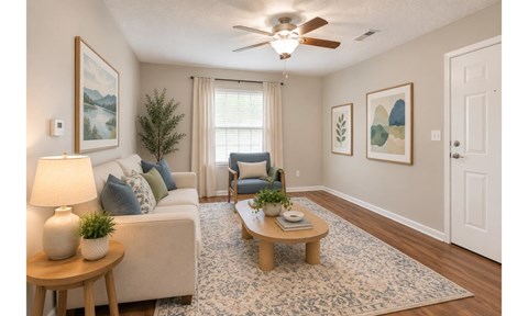 A living room with a white couch, a wooden coffee table, and a ceiling fan.
