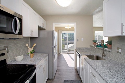 White Kitchen with Stainless-Steel Appliances and Granite Countertops