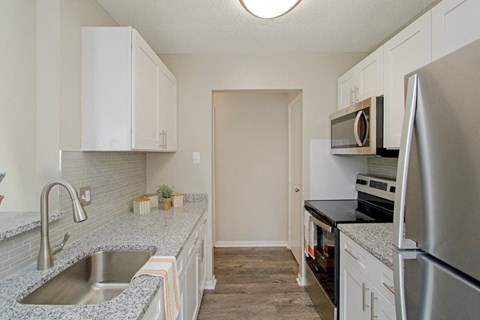 White Kitchen with Stainless-Steel Appliances and Granite Countertops