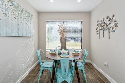 a dining room with a table and chairs and a window