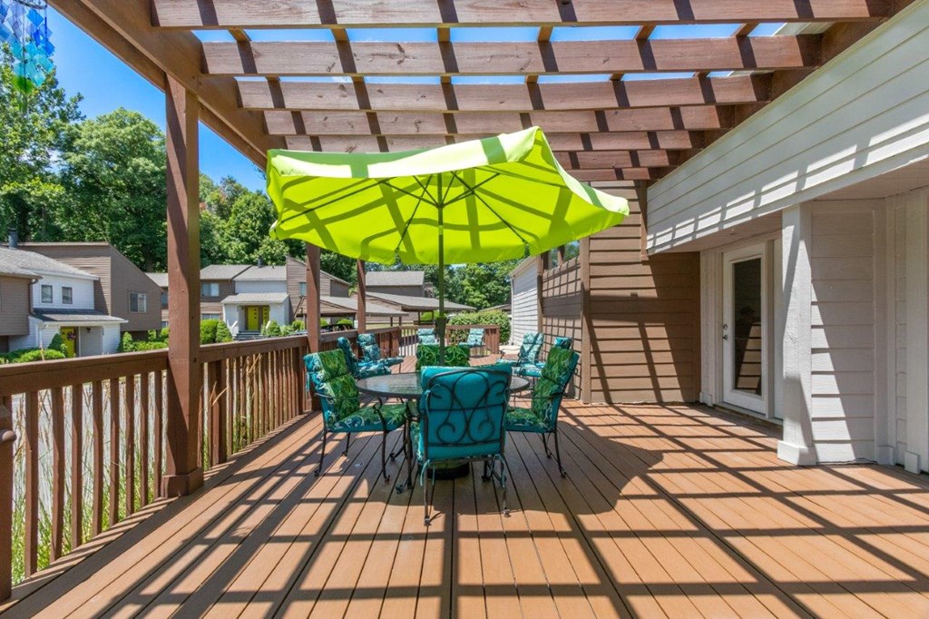 a patio with a table and chairs under a roof