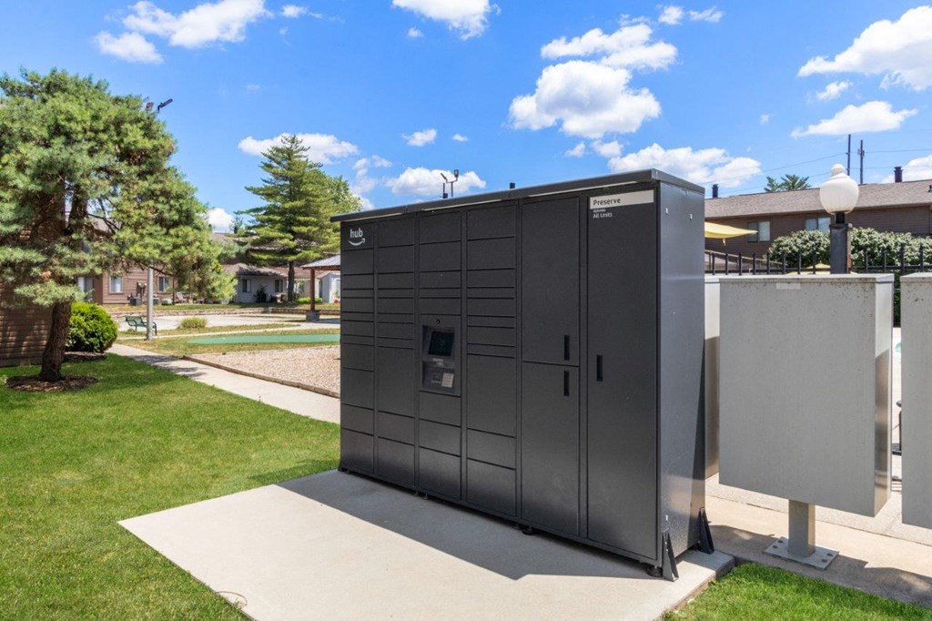 a small metal building on the grass next to a sidewalk