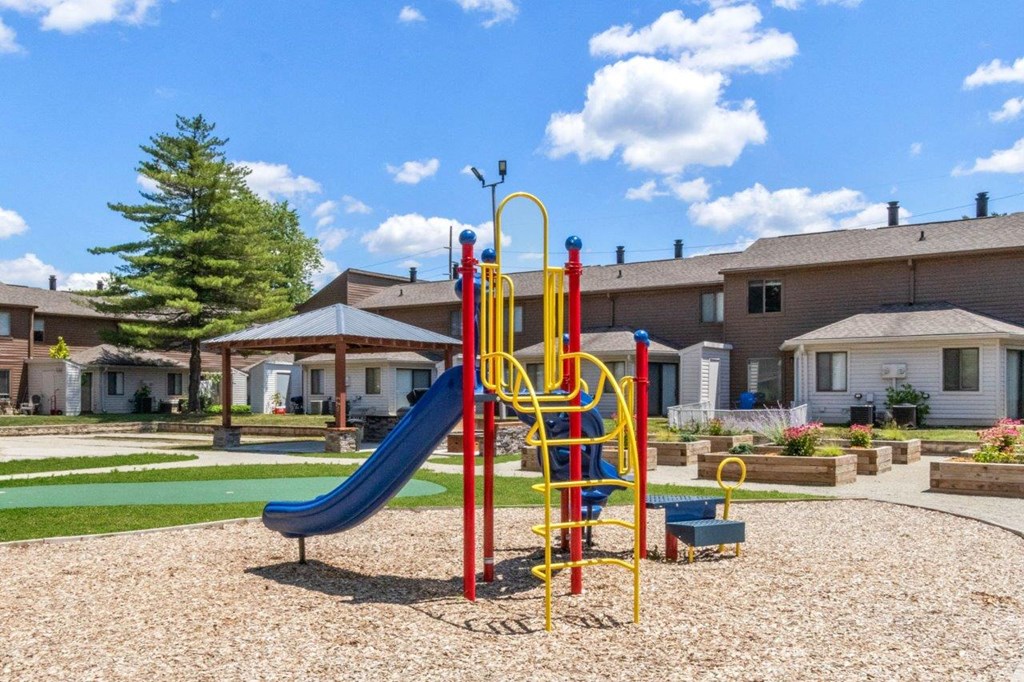 a playground in a yard with houses in the background