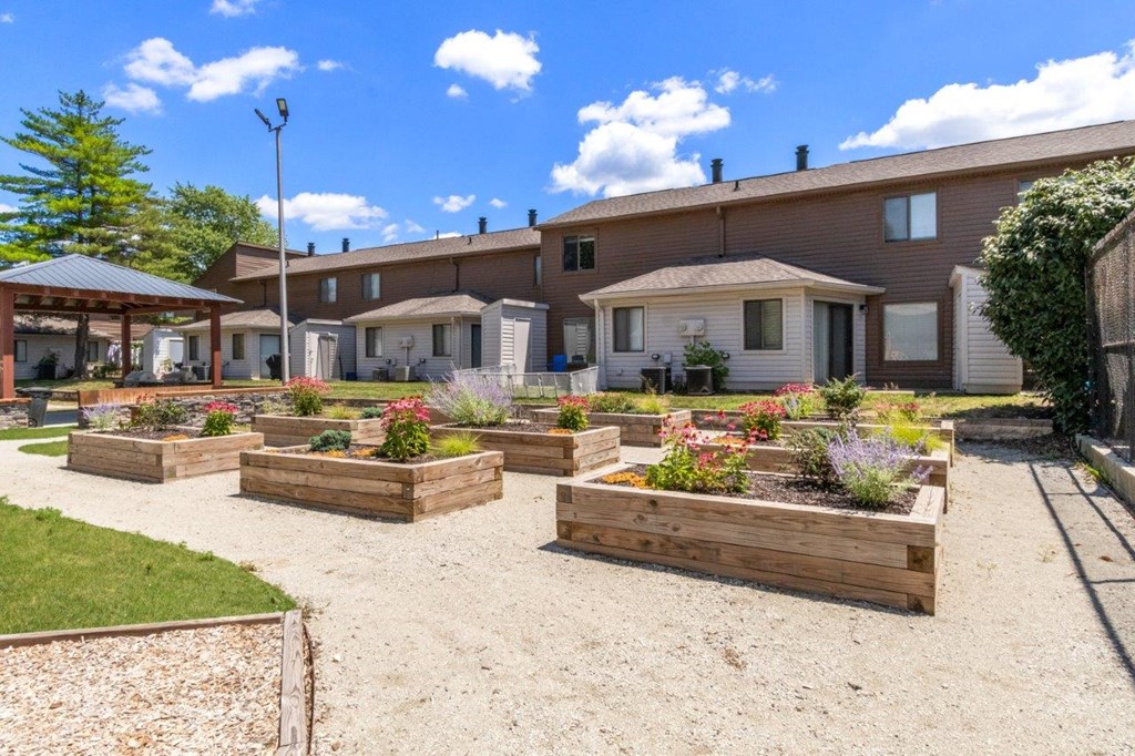 a yard with wooden planters in front of a house