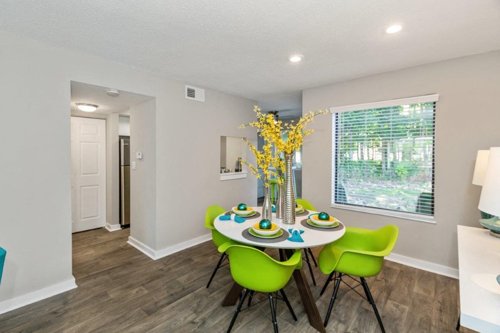 a dining room with a table and chairs and a window