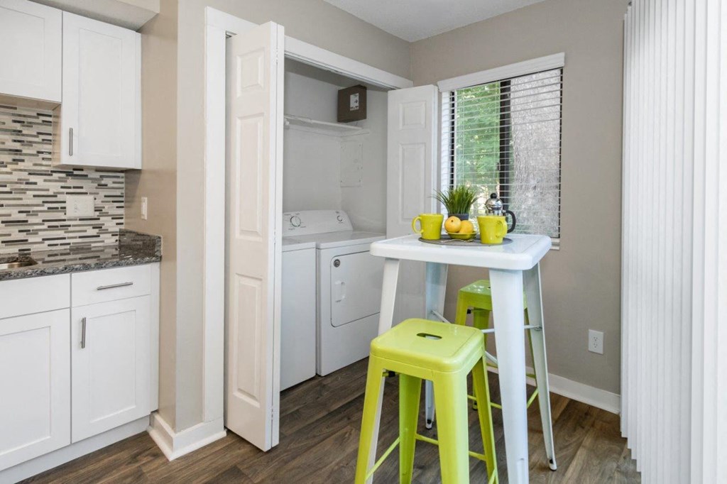 a small kitchen with a bar and yellow stools