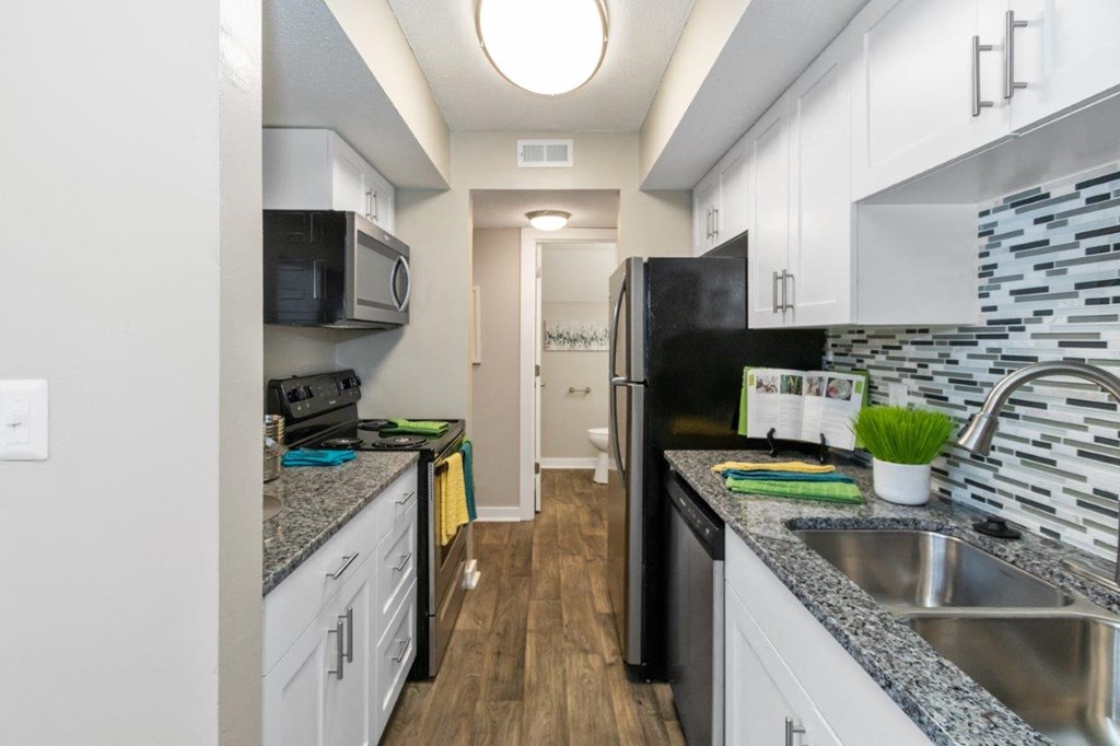 a kitchen with white cabinets and a black refrigerator