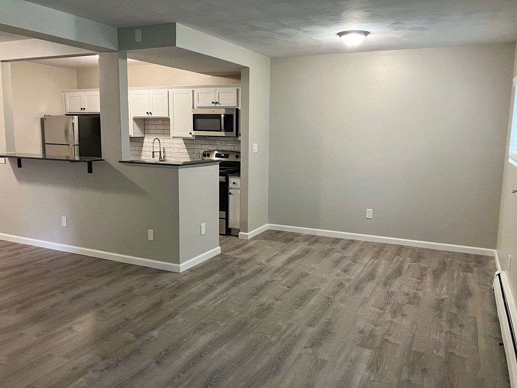 A kitchen with a refrigerator, microwave, and oven.