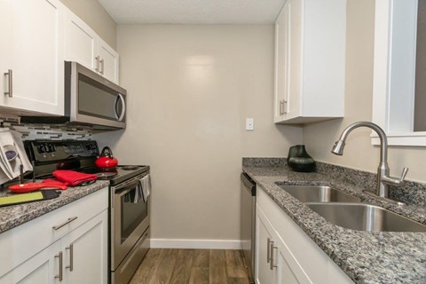 White Kitchen with Stainless-Steel Appliances and Granite Countertops