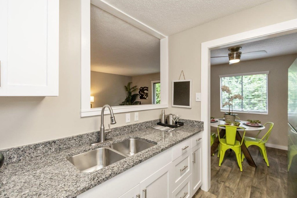 White Kitchen with Stainless-Steel Appliances and Granite Countertops