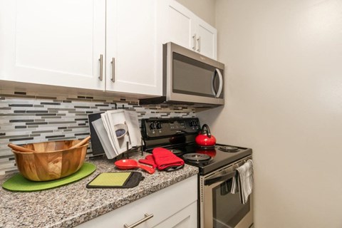 White Kitchen with Stainless-Steel Appliances and Granite Countertops